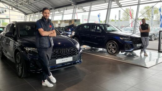 Deix Audi Q5 bleu avec nos deux Audi expert appuyés contre chaque véhicule